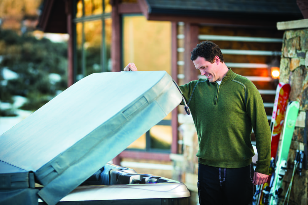 man closing hot tub with cover